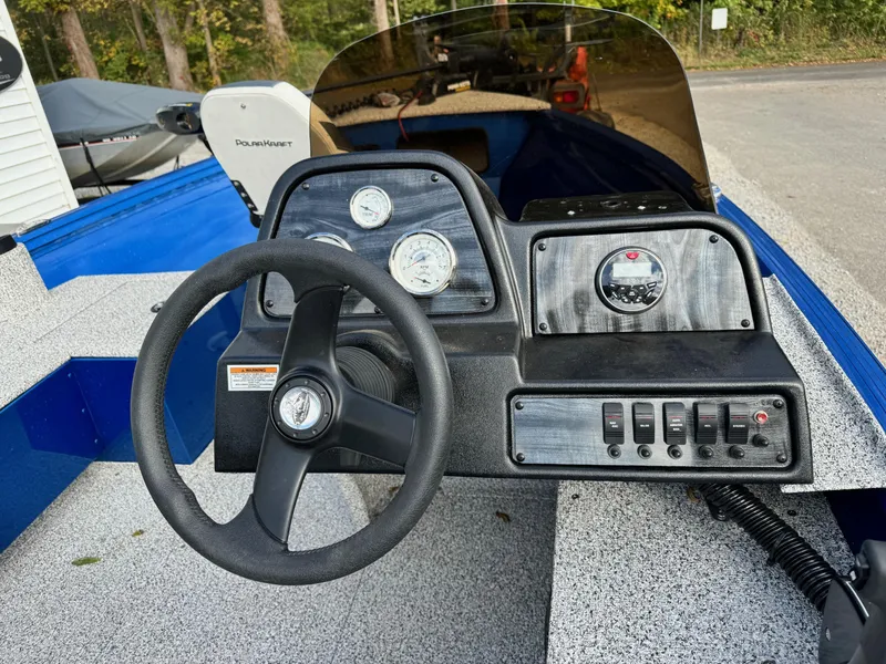 Slide: The Image of 2024 Polar Kraft Outlander 165 boat dashboard with steering wheel and control panel. - 5