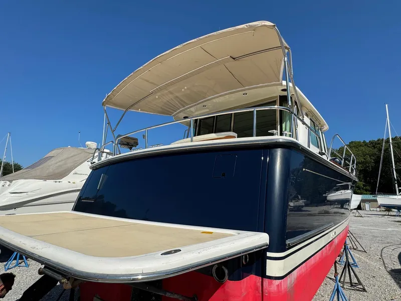 Slide: The Image of 2012 Sabre 48 Salon Express yacht with canopy, docked on land. - 14