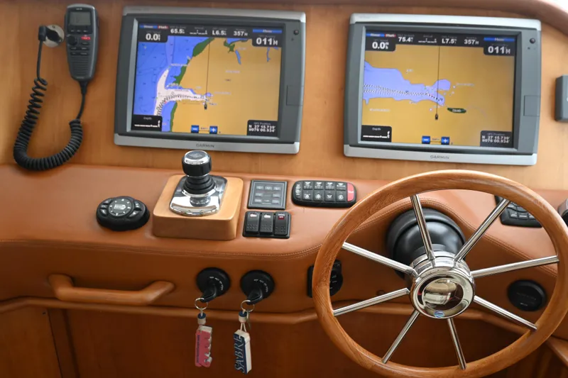 Slide: The Image of 2012 Sabre 48 Salon Express helm with dual navigation screens and wooden steering wheel. - 17