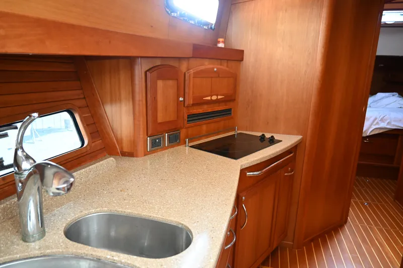 Slide: The Image of 2012 Sabre 48 Salon Express yacht kitchen with wood cabinetry and modern appliances. - 18