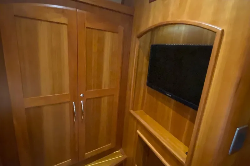 Slide: The Image of 2012 Sabre 48 Salon Express interior with wooden cabinetry and mounted TV. - 34