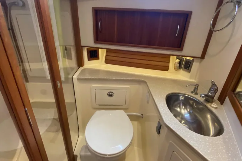 Slide: The Image of 2012 Sabre 48 Salon Express bathroom with shower, sink, and wooden cabinetry. - 35