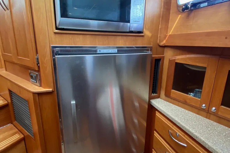 Slide: The Image of 2012 Sabre 48 Salon Express kitchen with stainless steel fridge and microwave. - 37