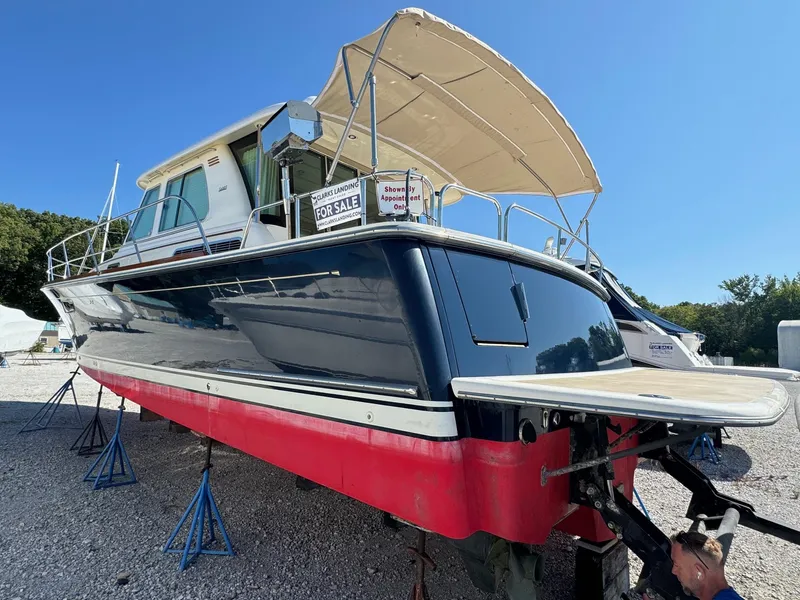 Slide: The Image of 2012 Sabre 48 Salon Express boat for sale, displayed on stands, with a canopy. - 4