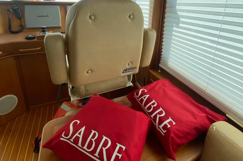 Slide: The Image of Interior of 2012 Sabre 48 Salon Express with red Sabre pillows and beige seating. - 45