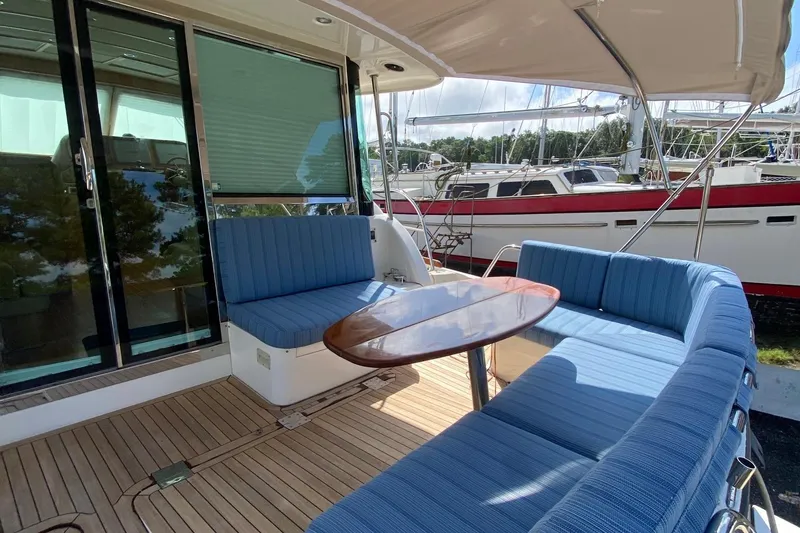 Slide: The Image of 2012 Sabre 48 Salon Express yacht with blue seating and wooden table on deck. - 46