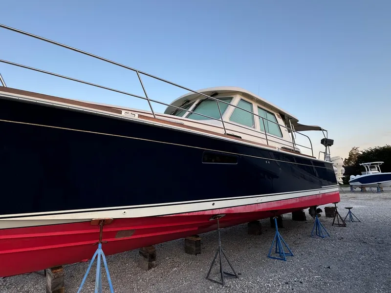 Slide: The Image of 2012 Sabre 48 Salon Express yacht on stands, blue hull, red bottom, outdoor setting. - 48