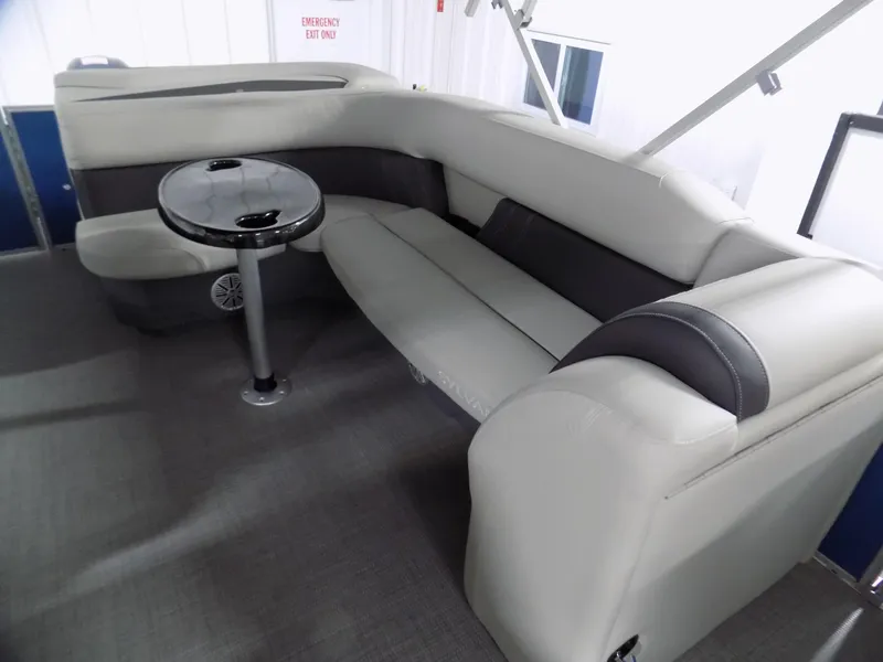 Slide: The Image of 2024 Sylvan 8522 Mirage Cruise boat interior with plush seating and a small table. - 3