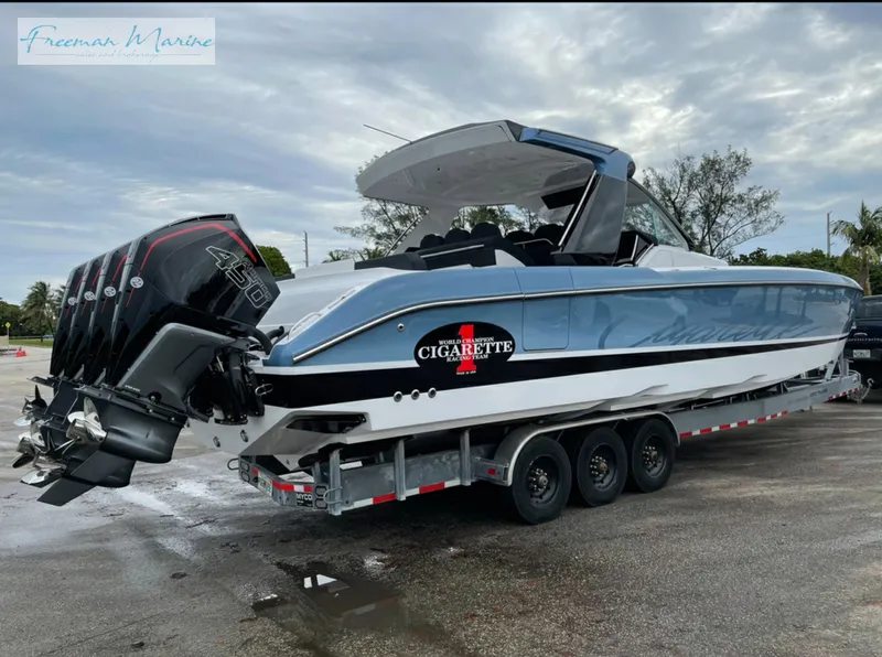 Slide: The Image of 2021 Cigarette 41 Nighthawk boat on a trailer with triple outboard engines. - 2