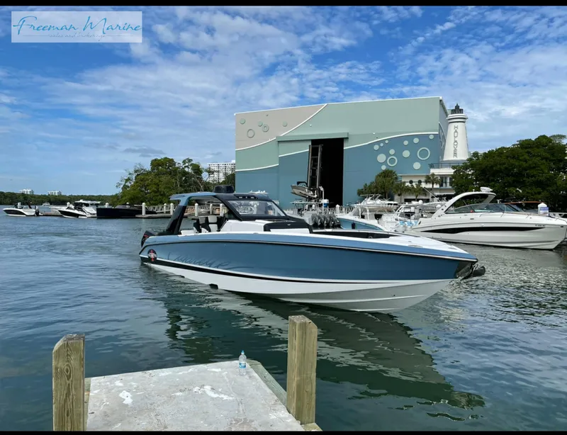 Slide: The Image of 2021 Cigarette 41 Nighthawk boat docked near a marina with other boats. - 24
