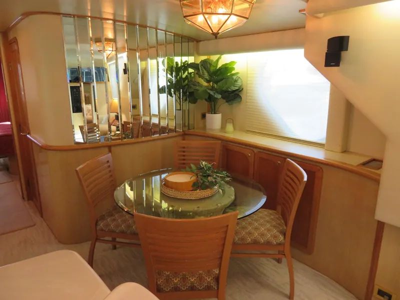 Slide: The Image of Interior dining area of 2000 Bluewater Yachts 5800 Motor Yacht with glass table and wooden chairs. - 22