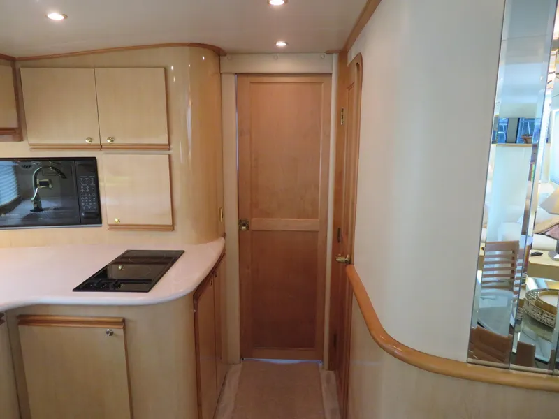 Slide: The Image of Interior of 2000 Bluewater Yachts 5800 Motor Yacht kitchen area with wooden cabinetry. - 28