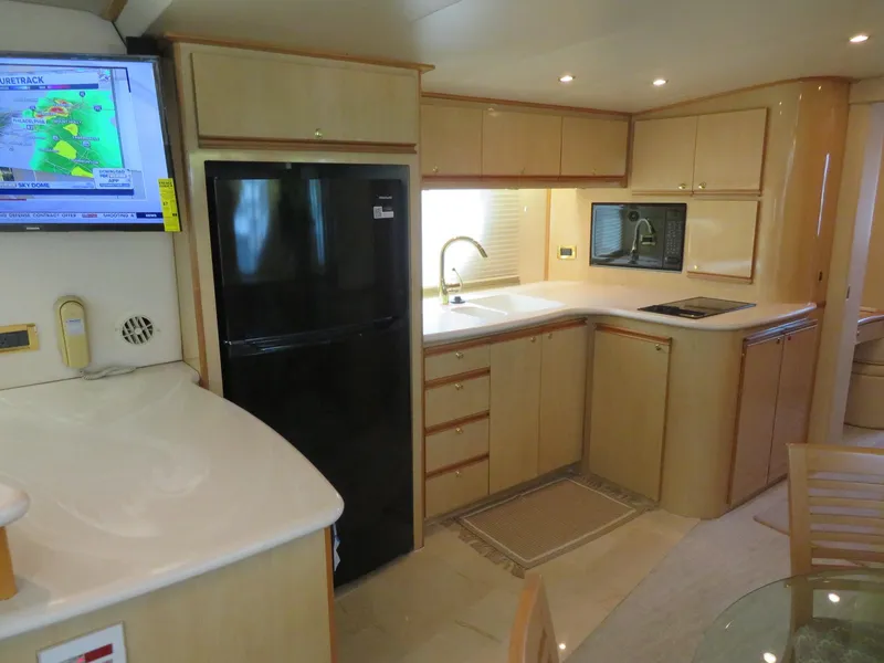 Slide: The Image of Modern kitchen in 2000 Bluewater Yachts 5800 Motor Yacht with black fridge and TV. - 29