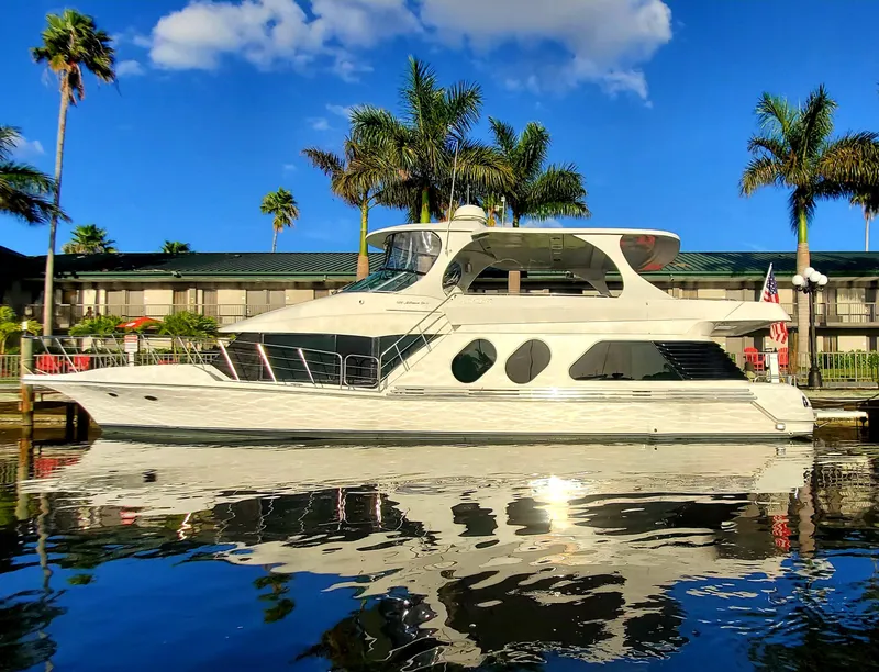 Slide: The Image of 2000 Bluewater Yachts 5800 Motor Yacht docked by palm trees and a building. - 3
