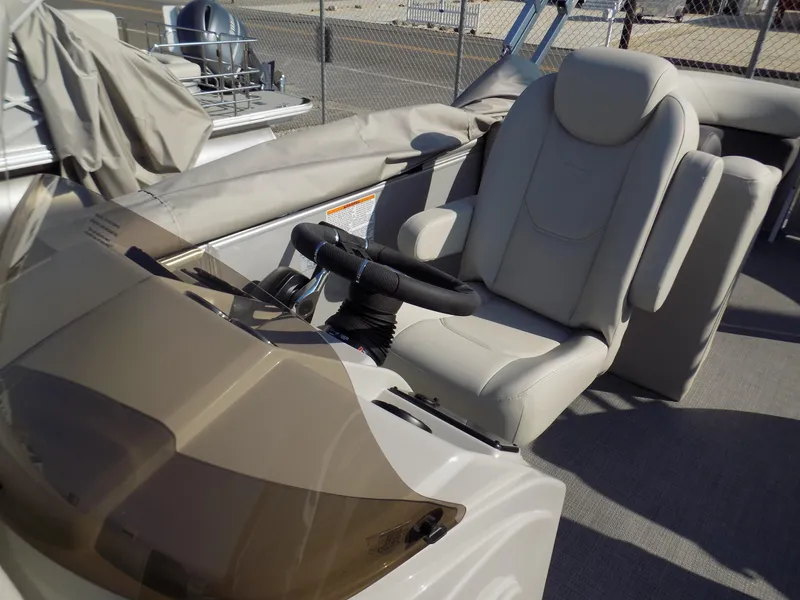 Slide: The Image of 2024 Sylvan Mirage 8522 LZ boat interior with steering wheel and captain's chair. - 8