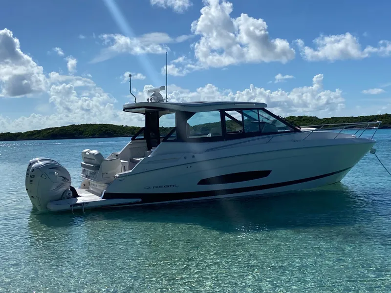 The Image of 2023 Regal 36 XO boat anchored in clear blue water under a sunny sky. - 0