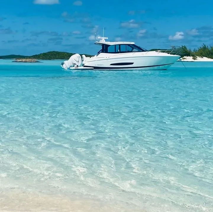 Slide: The Image of 2023 Regal 36 XO boat anchored in clear turquoise waters. - 12