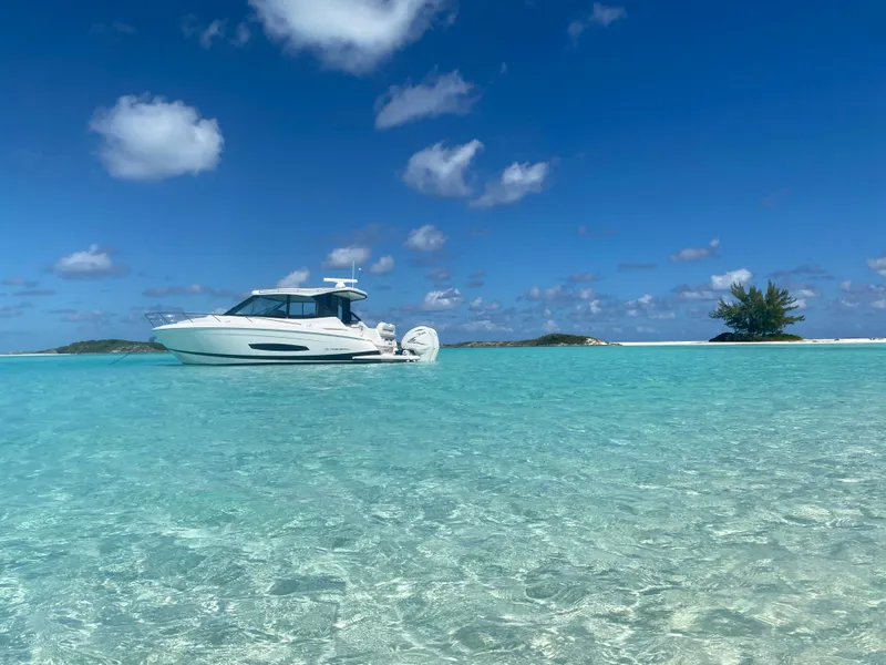 Slide: The Image of 2023 Regal 36 XO boat on clear turquoise water under a blue sky. - 15
