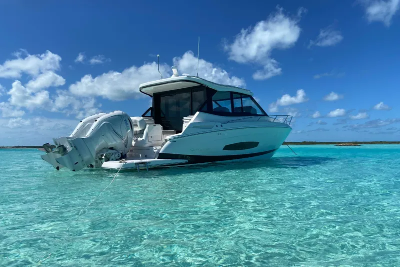 Slide: The Image of 2023 Regal 36 XO boat anchored in clear turquoise water under a blue sky. - 19