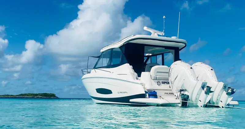 Slide: The Image of 2023 Regal 36 XO boat anchored in clear blue waters under a bright sky. - 3