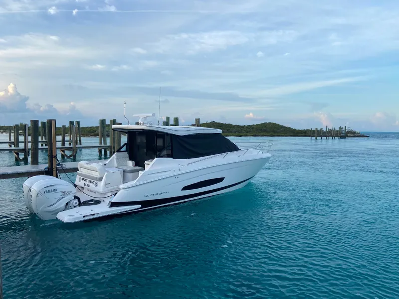 Slide: The Image of 2023 Regal 36 XO boat docked in clear blue water. - 8