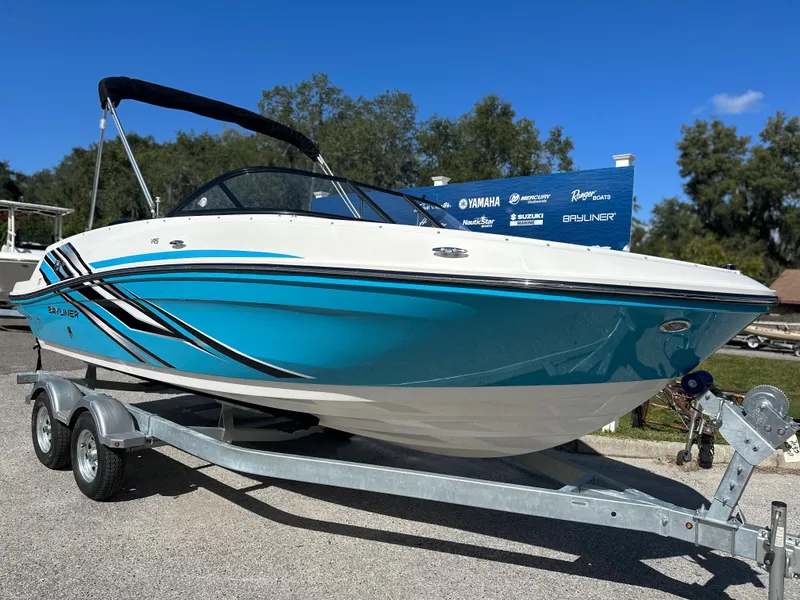 Slide: The Image of 2024 Bayliner VR5 Bowrider OB on a trailer, blue and white exterior. - 2