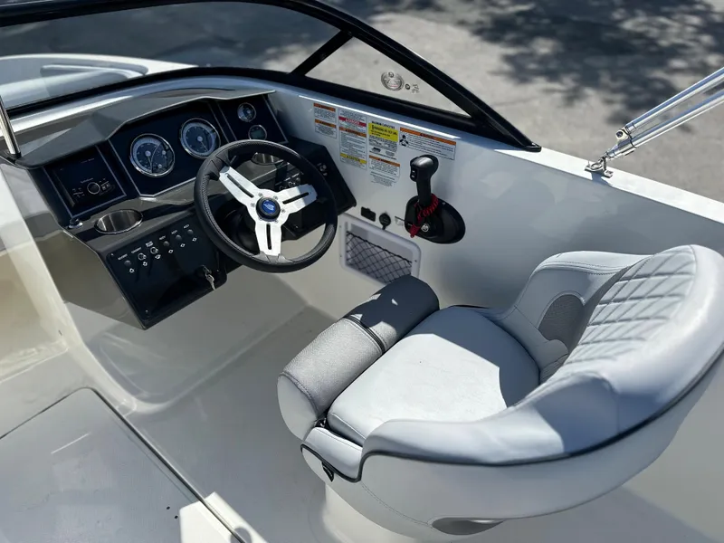 Slide: The Image of 2024 Bayliner VR5 Bowrider OB cockpit with steering wheel and captain's chair. - 10