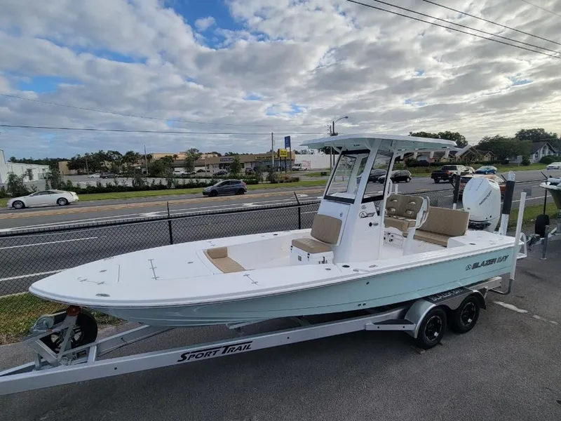 Slide: The Image of 2024 Blazer 2550 GTS boat on Sport Trail trailer, parked near a road. - 2