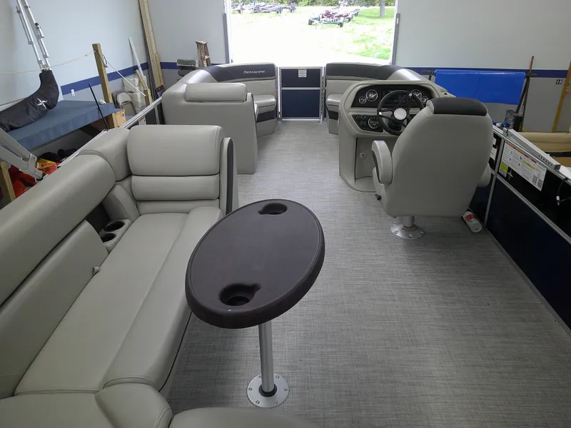 Slide: The Image of 2024 Berkshire 24CL LE 2.75 pontoon boat interior with plush seating and a central table. - 6
