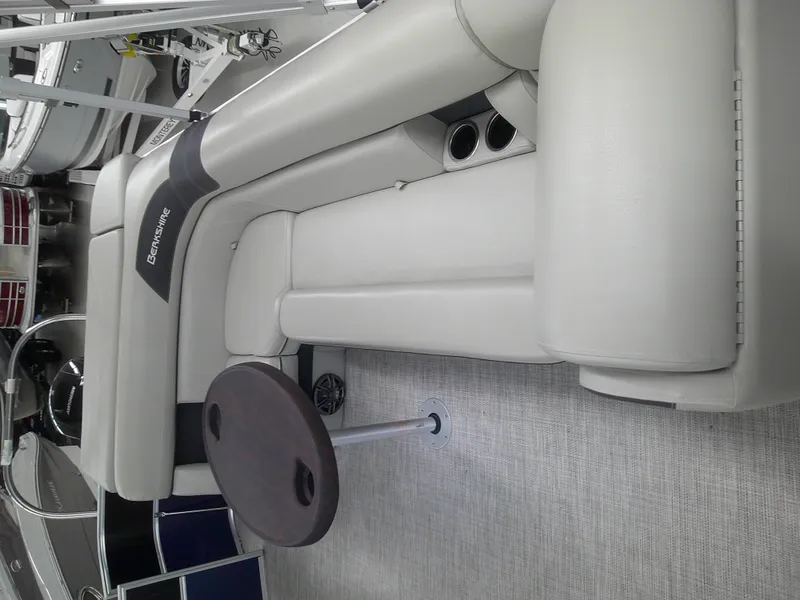 Slide: The Image of 2024 Berkshire 24CL LE 2.75 boat interior with beige seating and small round table. - 9