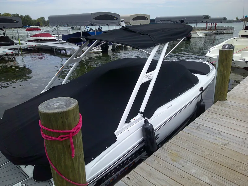 Slide: The Image of 2023 Monterey 218 SS Bowrider docked with black cover at marina. - 3