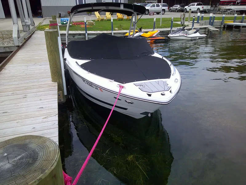 Slide: The Image of 2023 Monterey 218 SS Bowrider boat docked with black cover. - 4