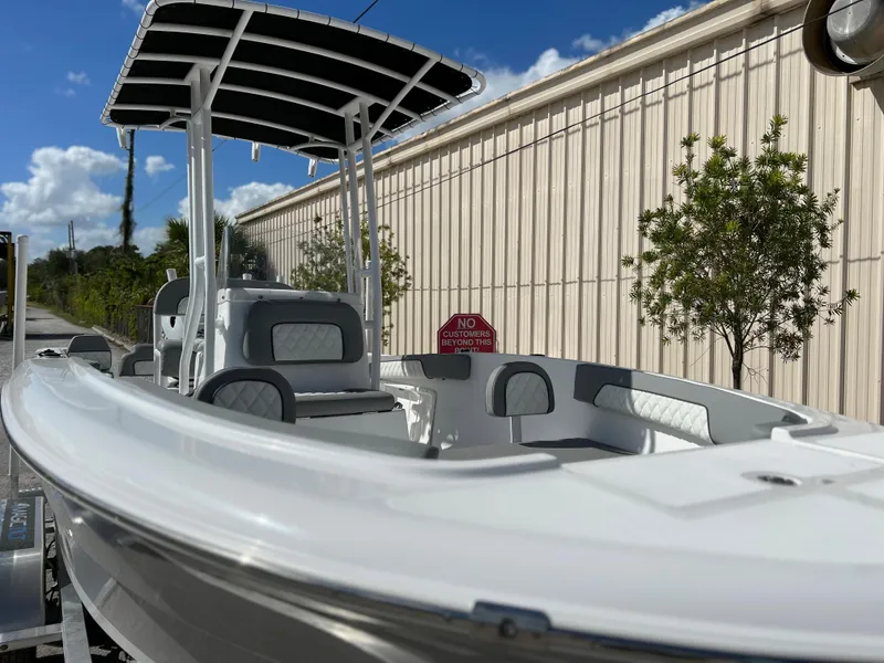 Slide: The Image of 2024 Clearwater 2000 boat with T-top, docked outdoors on a sunny day. - 12