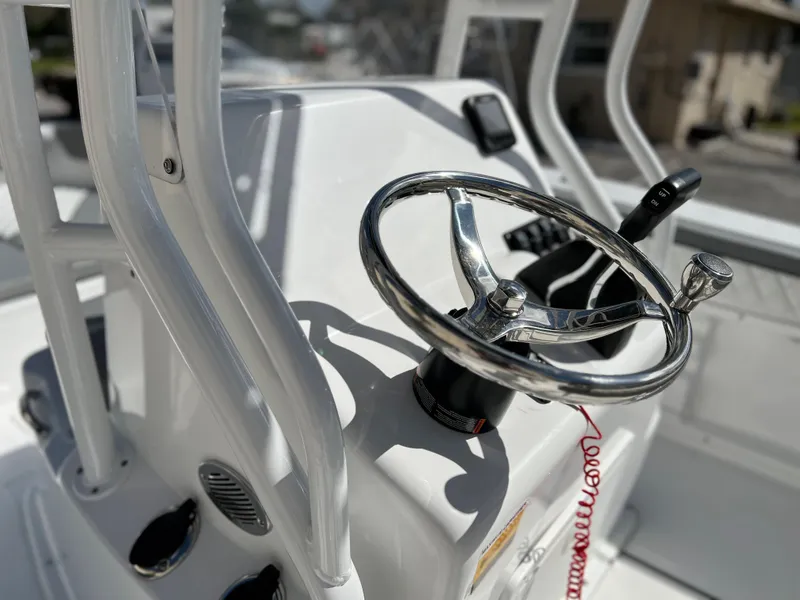 Slide: The Image of Close-up of the steering wheel and controls of a 2024 Clearwater 2000 boat. - 17