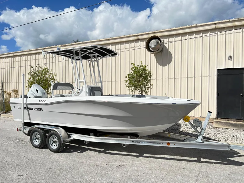 Slide: The Image of 2024 Clearwater 2000 boat on trailer, parked outdoors near a beige building. - 3