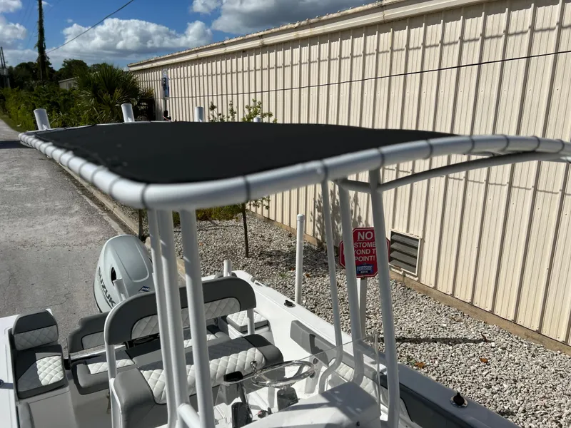 Slide: The Image of 2024 Clearwater 2000 boat with T-top and seating, parked outdoors. - 30