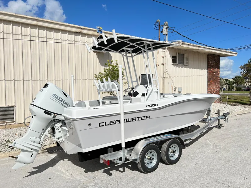 Slide: The Image of 2024 Clearwater 2000 boat on trailer with Suzuki outboard motor, parked outdoors. - 4