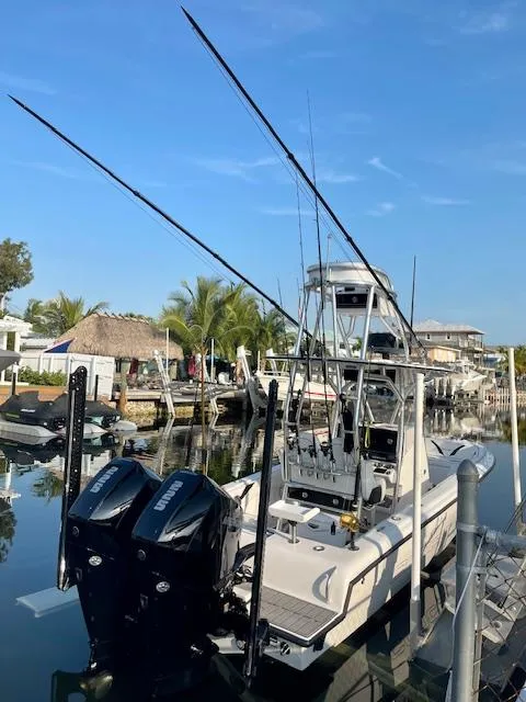 Slide: The Image of Modern Concept 27 fishing boat docked, featuring dual engines and fishing rods, 2023 model. - 2