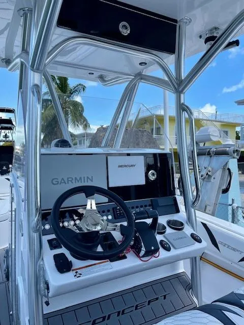 Slide: The Image of 2023 Concept 27 boat dashboard with Garmin and Mercury controls, docked near waterfront homes. - 4