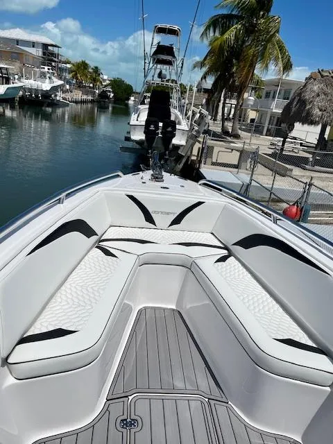 Slide: The Image of 2023 Concept 27 boat with sleek seating, docked in a sunny marina. - 7