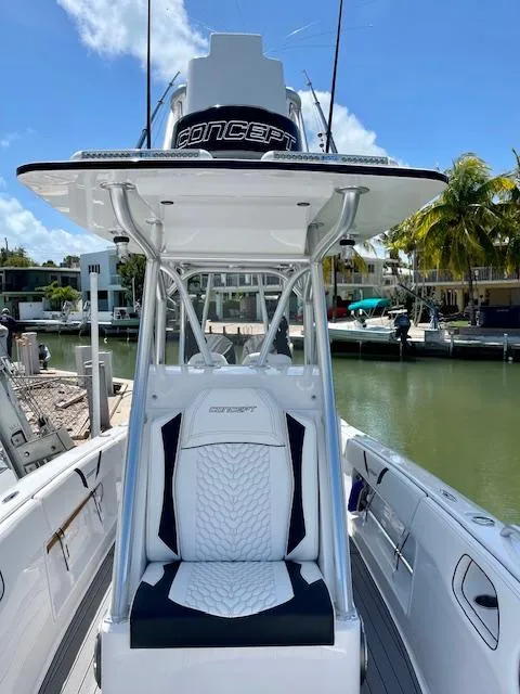 Slide: The Image of 2023 Concept 27 boat with sleek design, docked by waterfront homes under clear blue sky. - 8