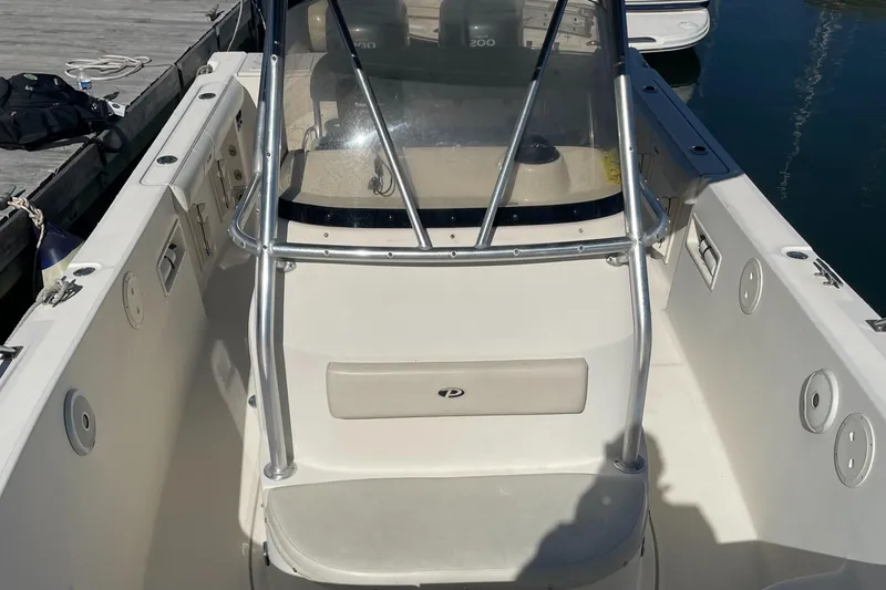 Slide: The Image of 2004 Pursuit 2670 Cuddy Console boat interior with seating and windshield. - 19