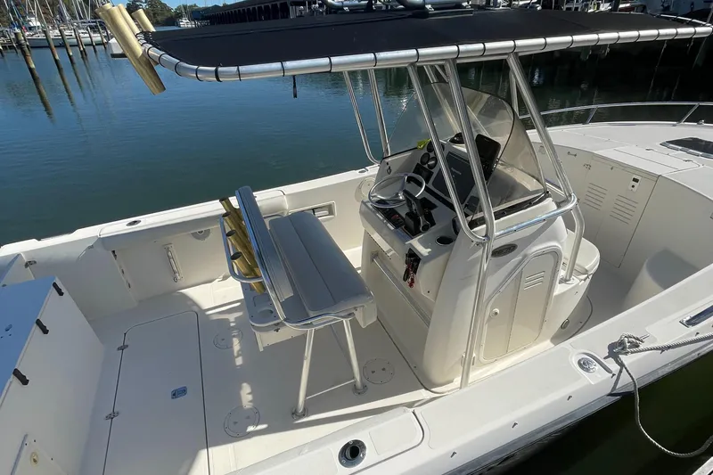 Slide: The Image of 2004 Pursuit 2670 Cuddy Console boat with center console and seating, docked in marina. - 24