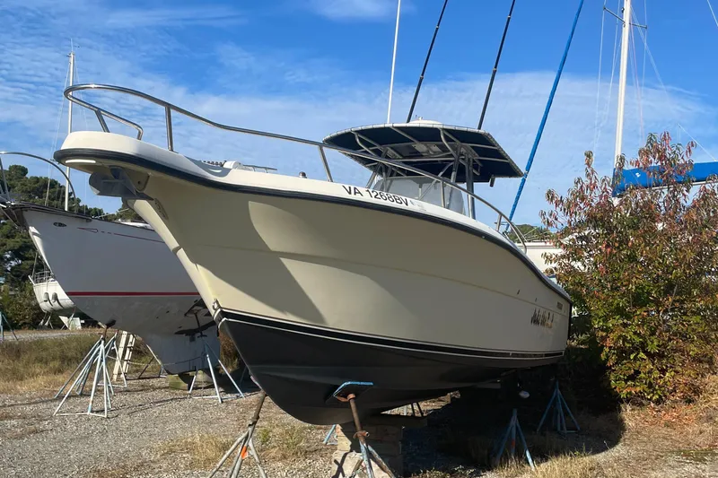 Slide: The Image of 2004 Pursuit 2670 Cuddy Console boat on stands in a yard. - 27