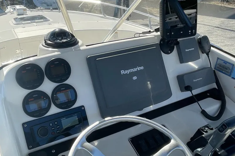 Slide: The Image of 2004 Pursuit 2670 Cuddy Console boat dashboard with Raymarine navigation system. - 32