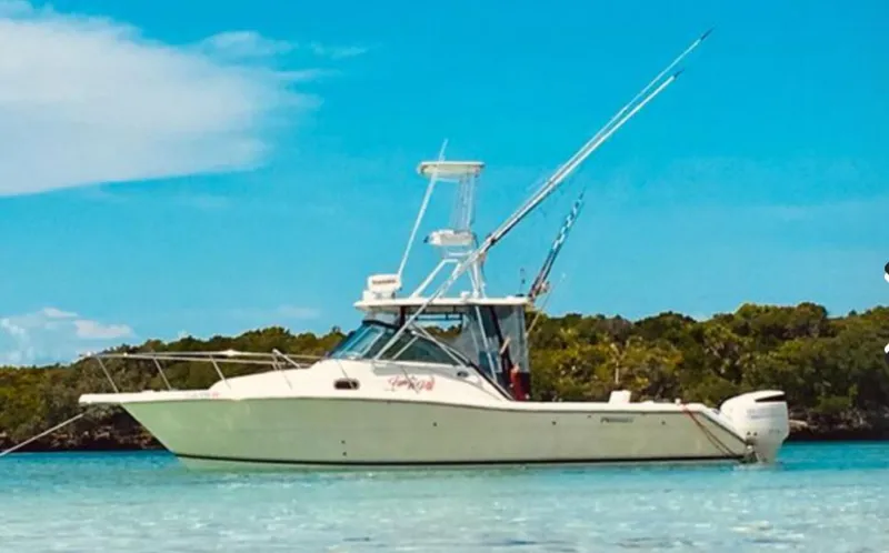 Slide: The Image of 2005 Pursuit 3070 Offshore boat anchored in clear blue water. - 1