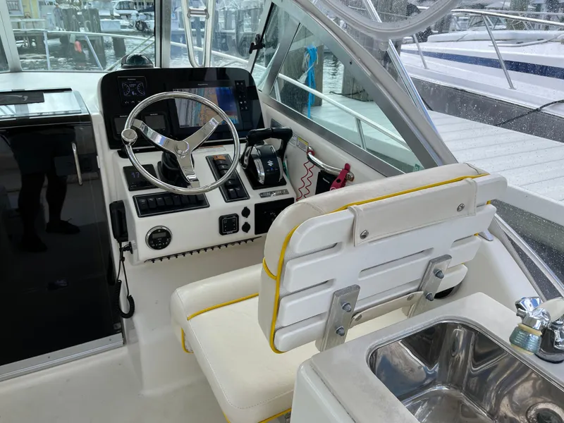 Slide: The Image of 2005 Pursuit 3070 Offshore boat cockpit with steering wheel and control panel. - 8