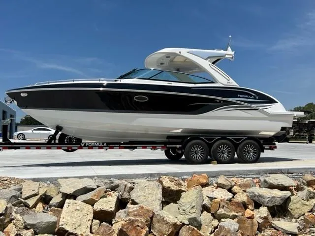 Slide: The Image of 2024 Formula 310 CBR boat on a trailer, parked outdoors. - 2