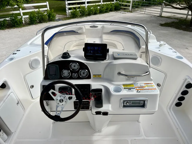 Slide: The Image of 2011 Hurricane 231 boat dashboard with steering wheel, gauges, and navigation system. - 10