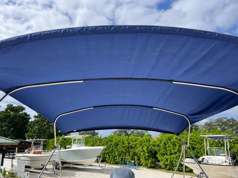 Slide: The Image of 2011 Hurricane 231 boat with blue bimini top in a marina. - 19